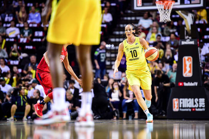 Sue Bird dribbles, wearing a nose mask